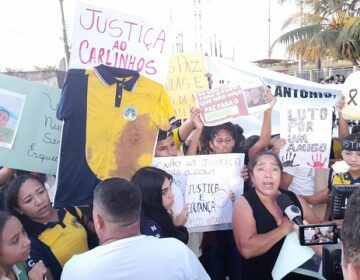 Em frente à escola onde aluno foi morto, comunidade protesta por segurança e justiça