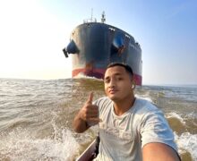 Jovem do AP desafia o perigo e viraliza ao navegar de rabeta com navio gigante