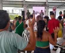 Famílias carentes agradecem orando ao receber alimentos