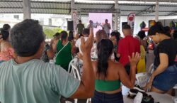 Famílias carentes agradecem orando ao receber alimentos