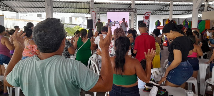 Famílias carentes agradecem orando ao receber alimentos