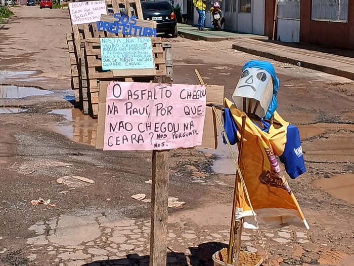 Ignorados, moradores protestam contra rua esburacada e alagada