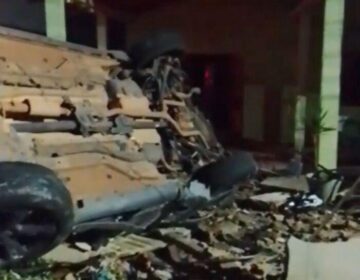 Motorista perde controle de caminhonete, capota e derruba muro de residência