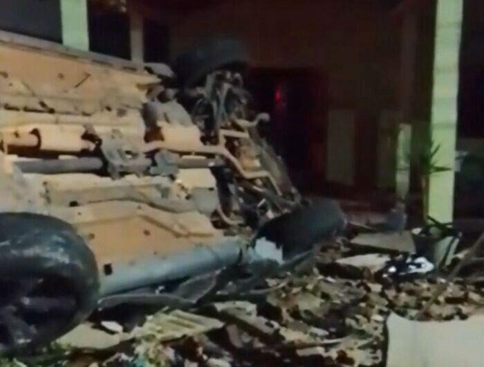 Motorista perde controle de caminhonete, capota e derruba muro de residência