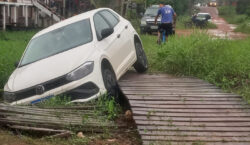 Motorista tenta encurtar caminho por ponte de madeira e carro acaba em canal
