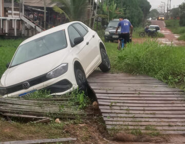 Motorista tenta encurtar caminho por ponte de madeira e carro acaba em canal