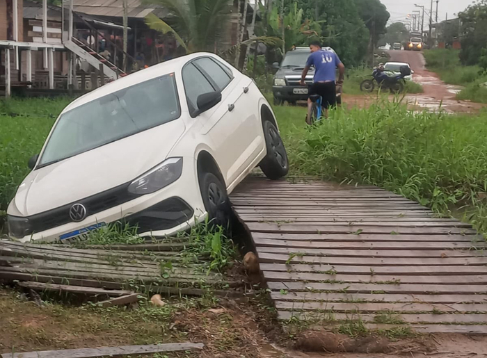 Motorista tenta encurtar caminho por ponte de madeira e carro acaba em canal